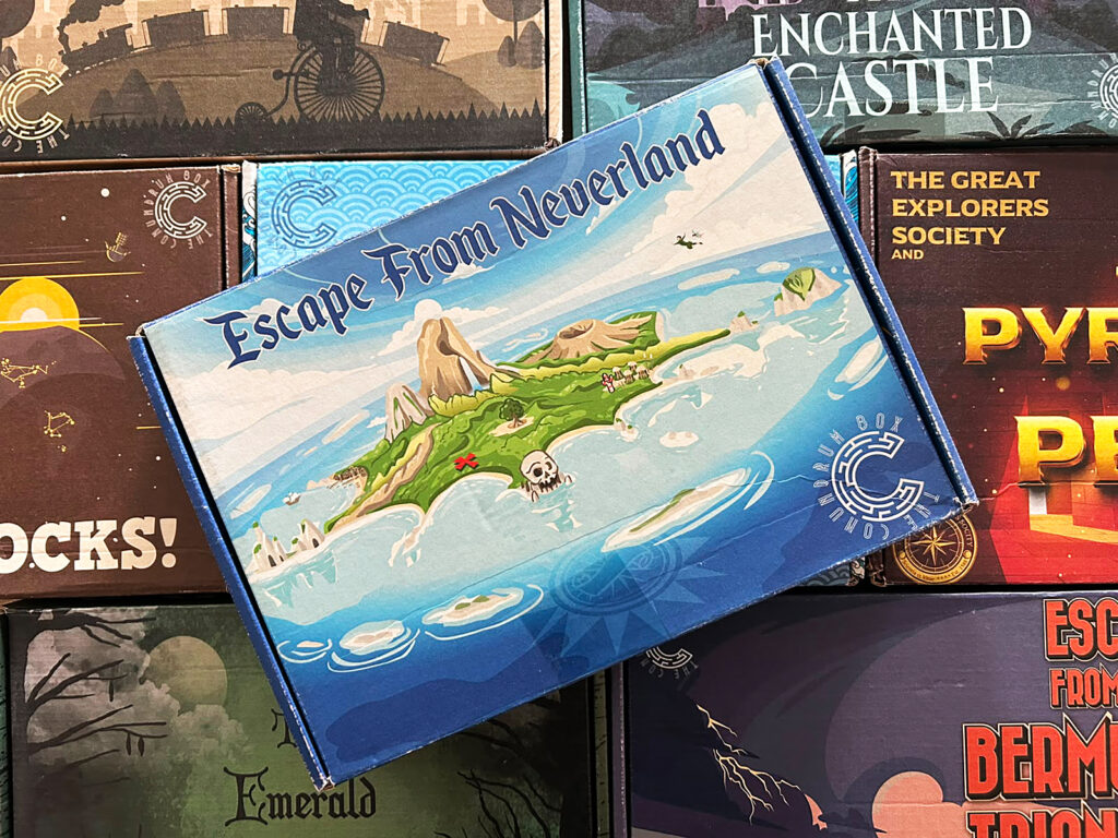 Das Foto zeigt einen Ausschnitt einer Spielesammlung: In einem Regal stapeln sich verschiedene bunte Schachteln des Anbieters The Conundrum Box.