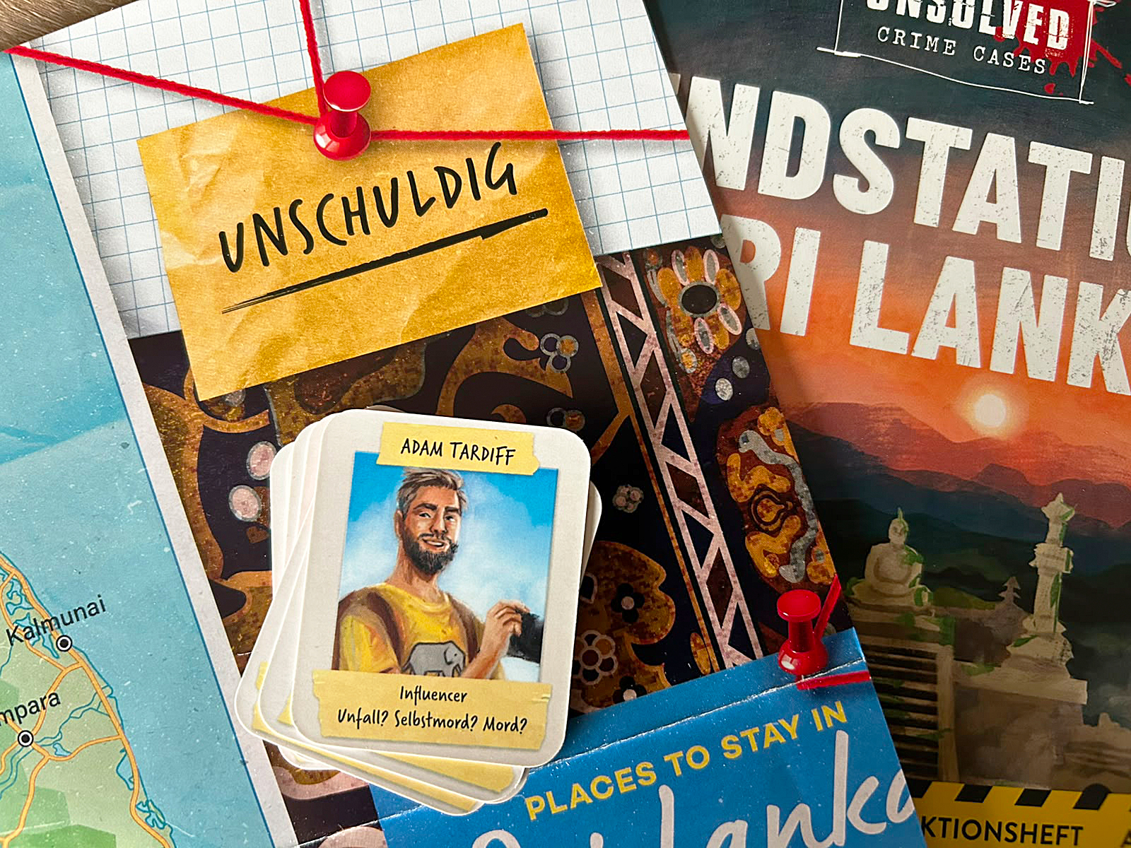 Eine Karte mit dem Bild von Reiseblogger Adam Tardiff liegt auf dem Spielmaterial von Endstation Sri Lanka.