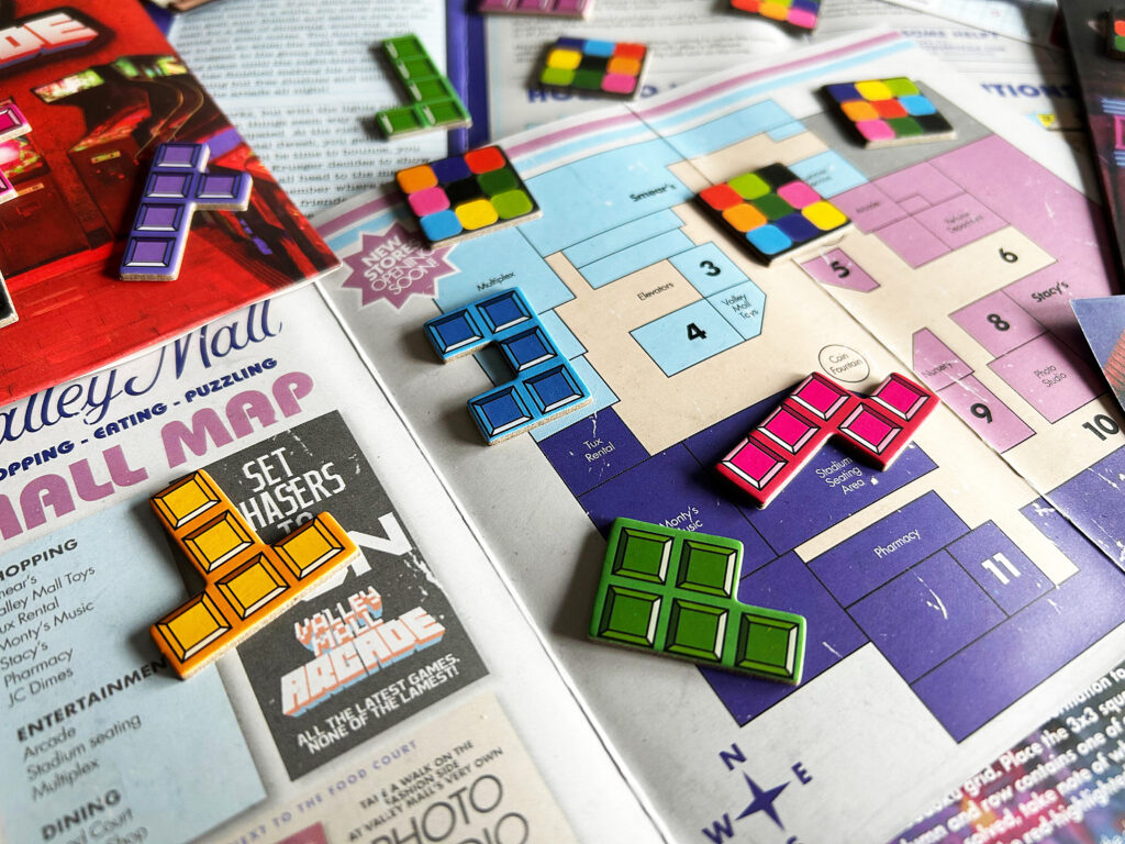 Das Spielmaterial aus dem Spiel „Escape from the Mall“ von Professor Puzzle liegt auf einem Tisch.