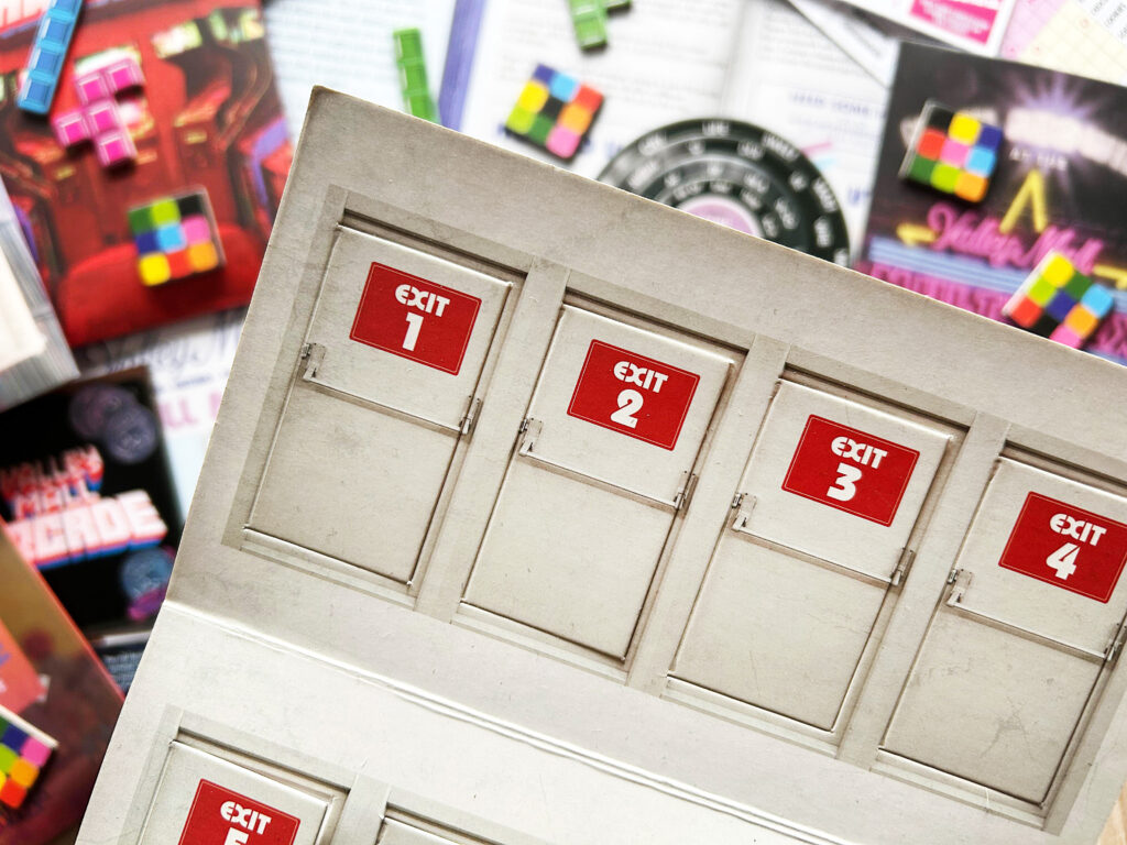 Material aus dem Spiel „Escape from the Mall“ von Professor Puzzle liegt auf einem Tisch.