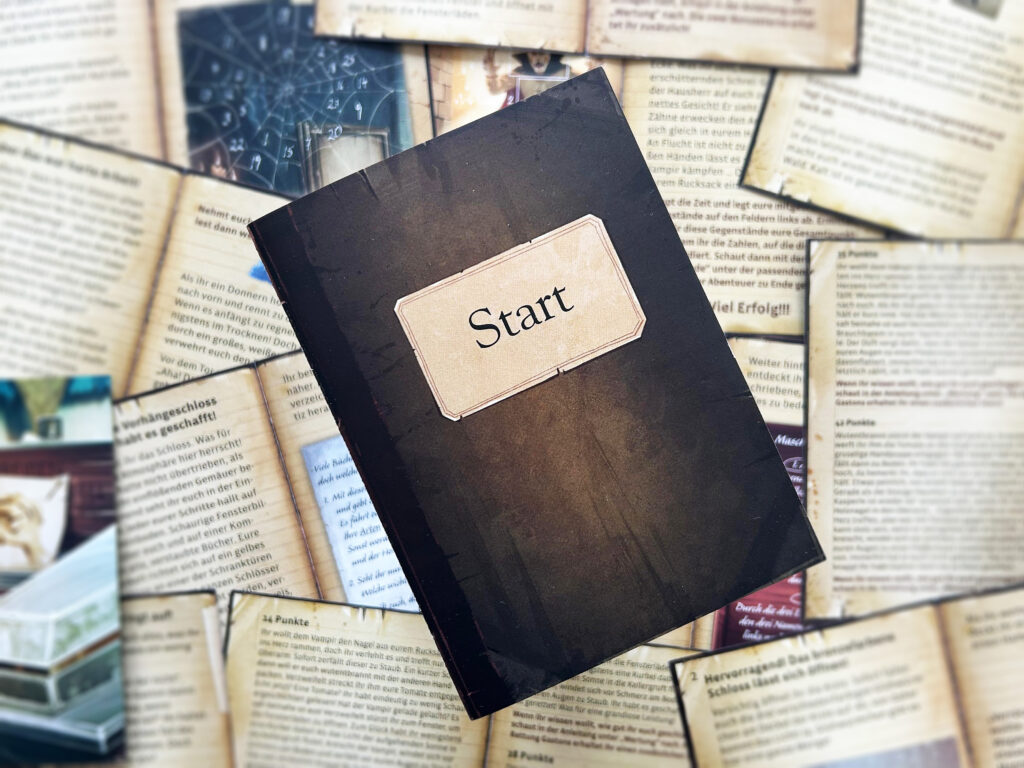Ein kleines Story-Heft mit der Aufschrift „Start“ liegt auf einem Stapel mit zahlreichen anderen aufgeschlagenen Story-Heften.