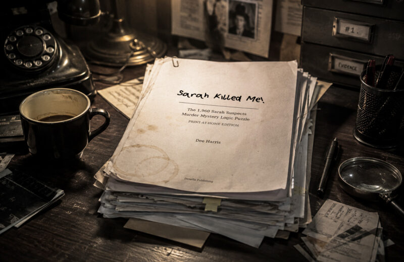 Das Bild zeigt einen Stapel Papier auf einem Detektiv-Schreibtisch, obenauf liegt das Deckblatt des Spiels „Sarah Killed Me!“.