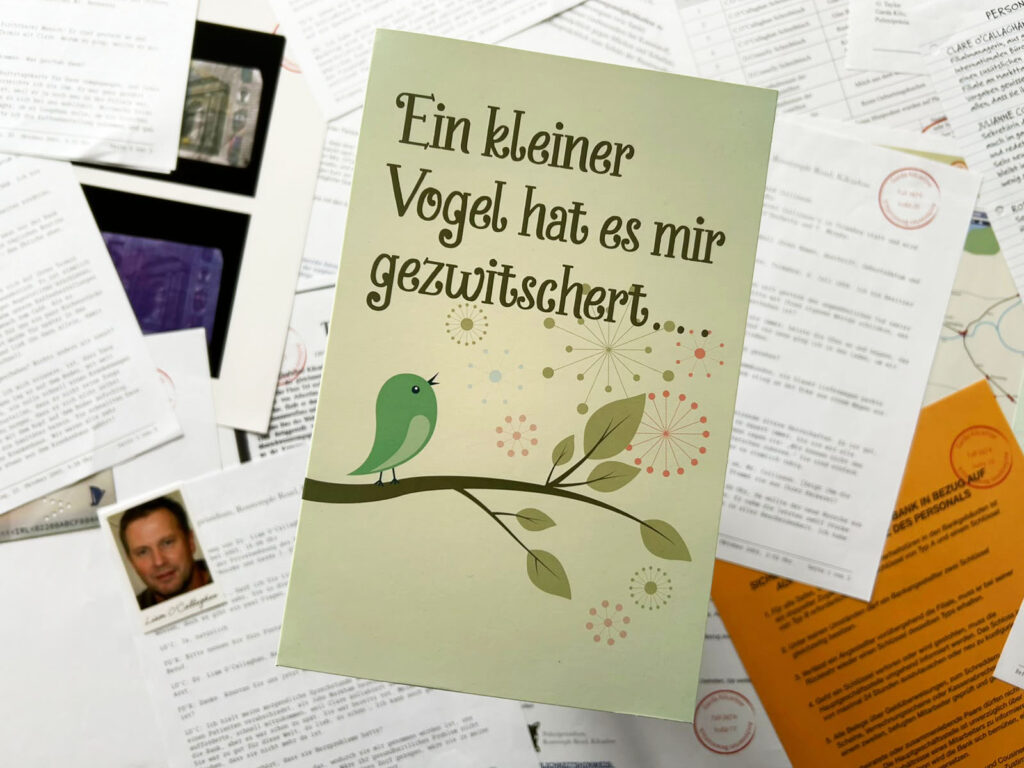 Das Spielmaterial des Spiels „Mord mit Zinsen“ liegt auf einem Tisch.