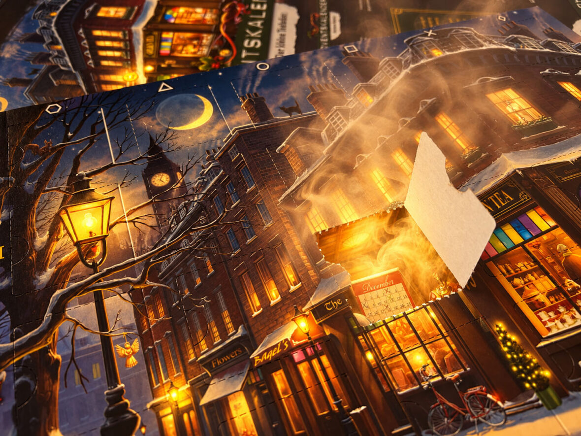 Ein Escape-Room-Adventskalender liegt auf einem Tisch, aus einem geöffneten Türchen steigt Nebel auf.