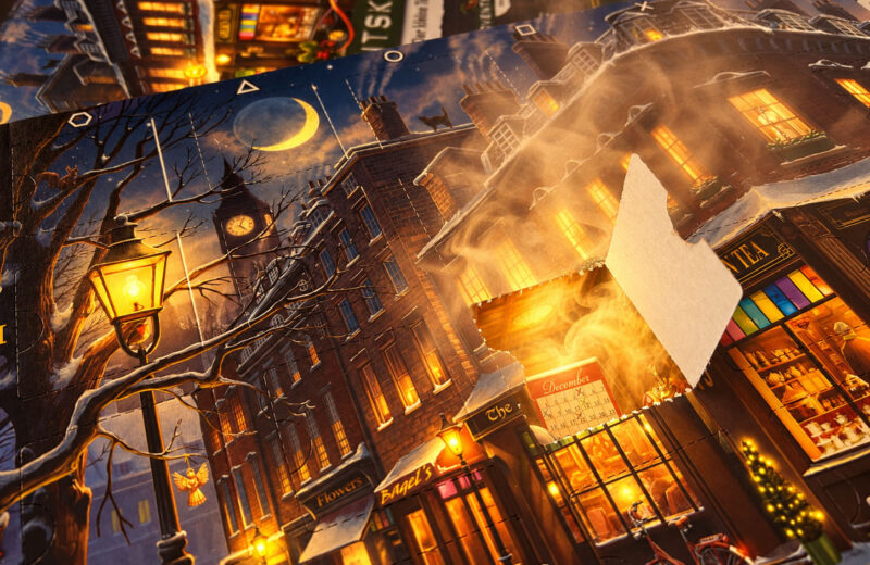 Ein Escape-Room-Adventskalender liegt auf einem Tisch, aus einem geöffneten Türchen steigt Nebel auf.