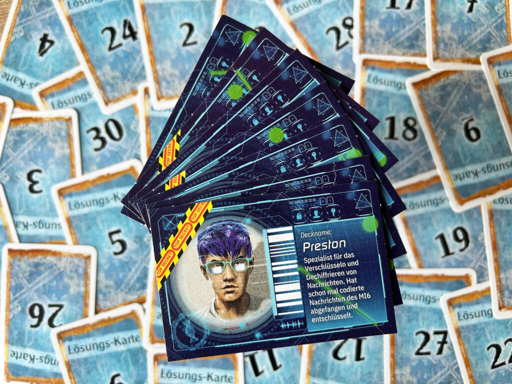 Mehrere Pappkarten aus dem Spiel „Der perfekte Einbruch“ von EXIT liegen auf dem Tisch.