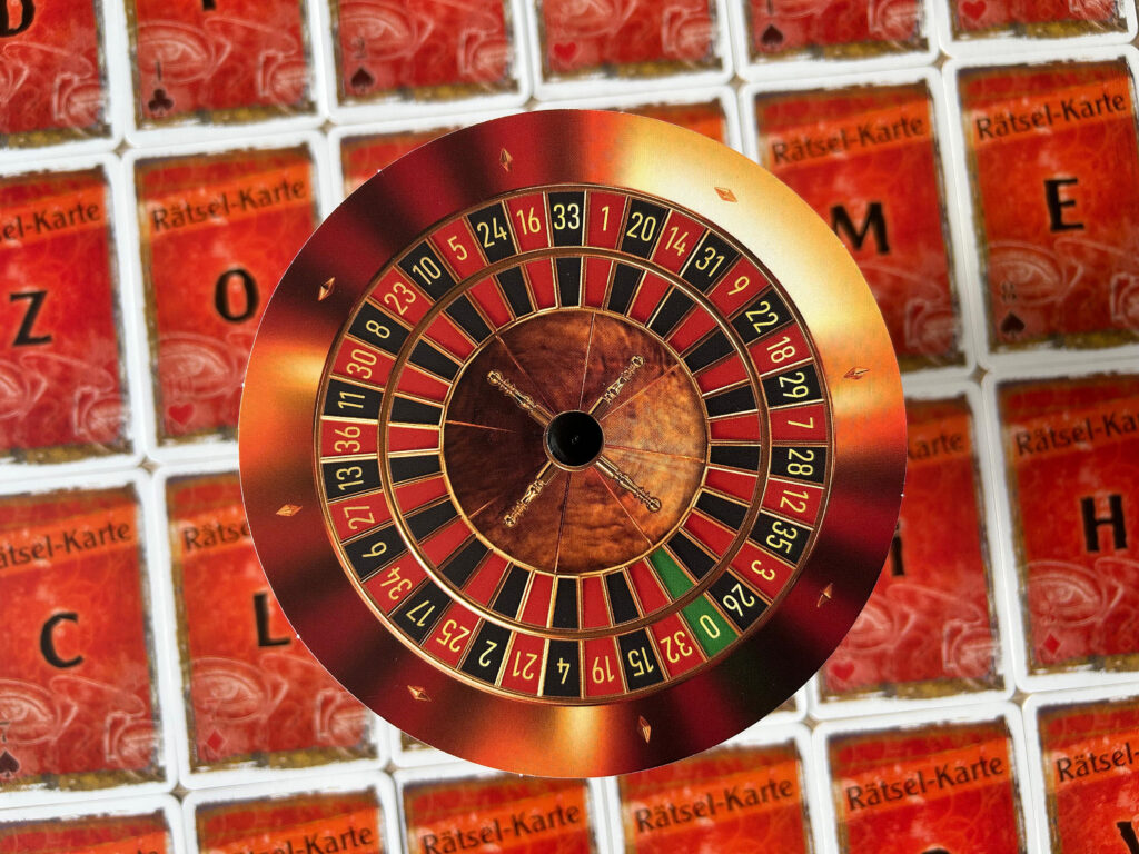 Rätselkarten und die Drehscheibe aus dem Spiel „Der perfekte Einbruch“ von EXIT liegen auf einem Tisch.