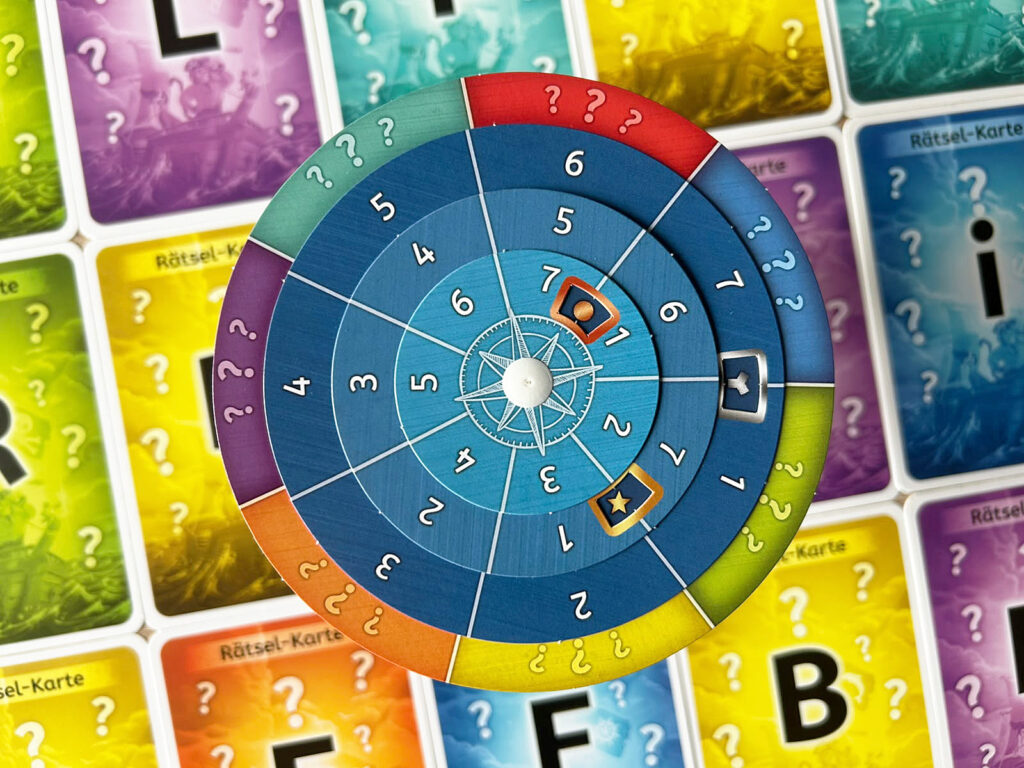 Die Codescheibe und mehrere Karten aus dem Spiel „Der verlorene Piratenschatz“ liegen auf einem Tisch.