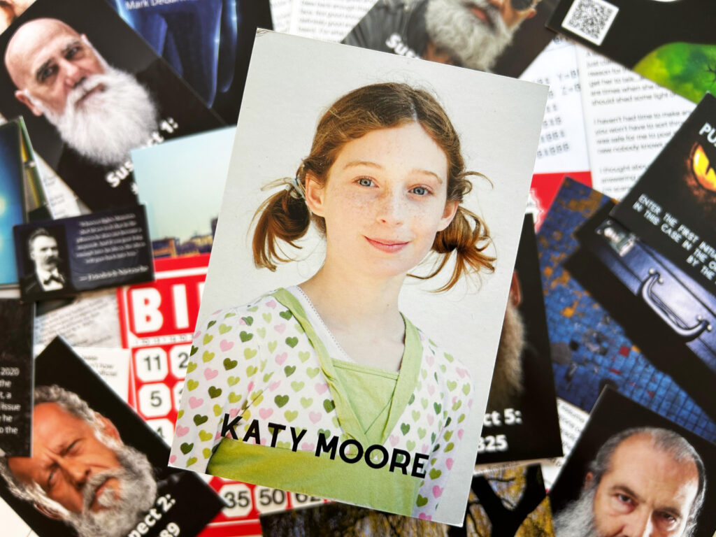 Eine Karte mit dem Bild eines Mädchens namens Katy Moore liegt auf einem Tisch.